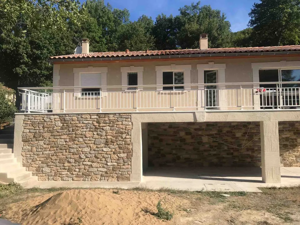 Façade en pierre taillee avec torchis gratté à l’ancienne sur l’étage à Saint-Pons de Thomières