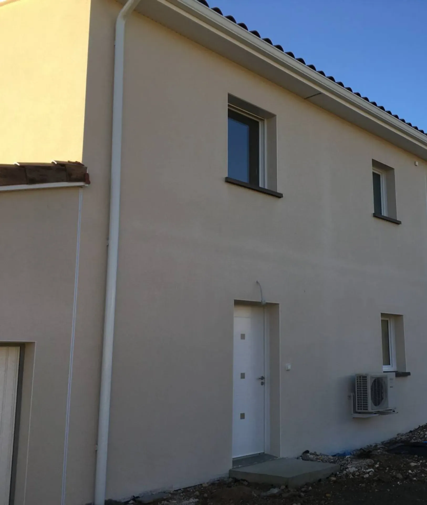 Façade avec unité extérieure de pompe à chaleur air-eau à L’Arbresle pour un chauffage performant et économique