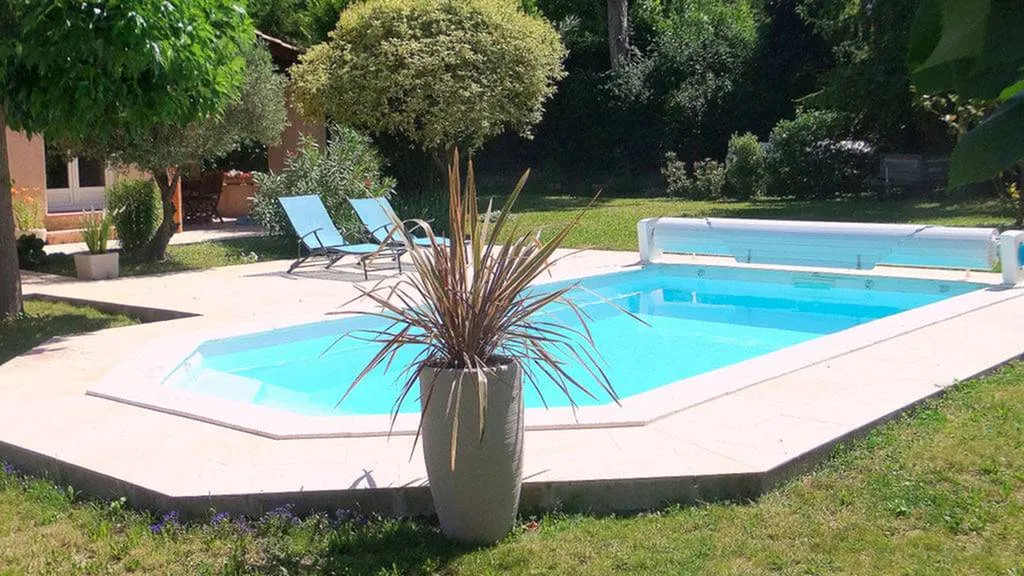 Piscine dans jardin avec enrouleur