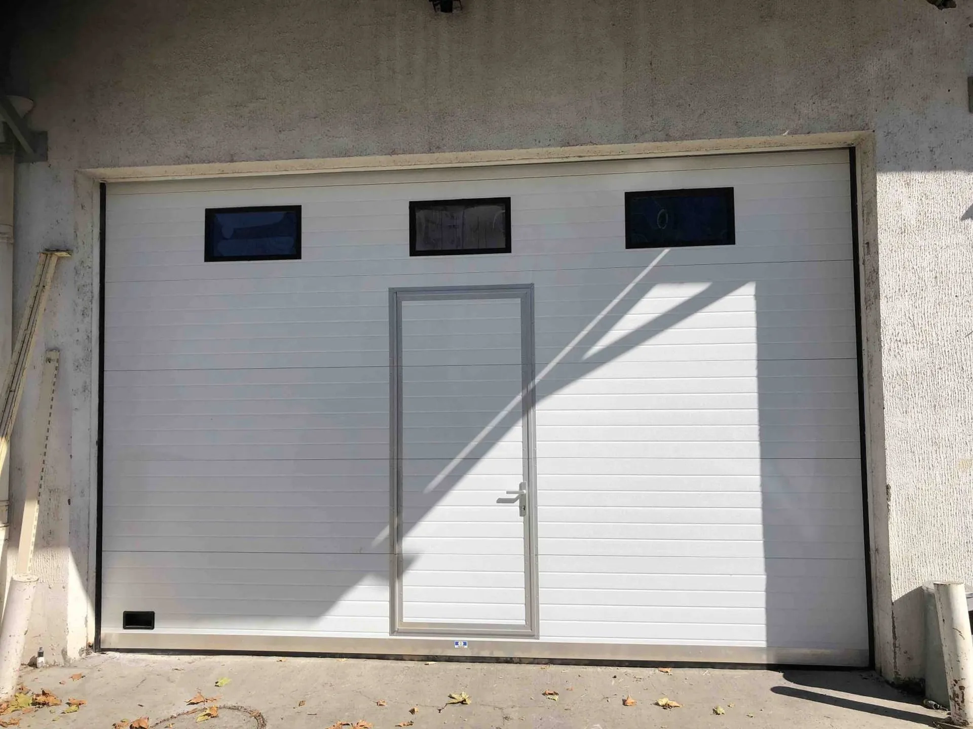 Remplacement d'une porte sectionnelle industrielle avec portillon et oculus près d'Aix en Provence et Marseille