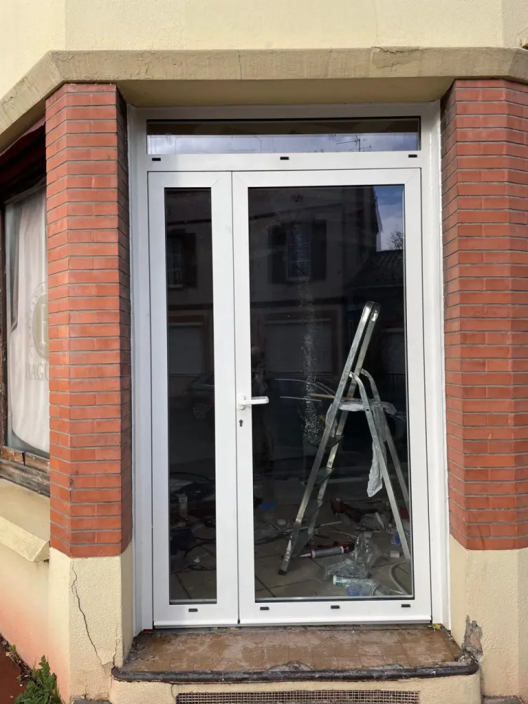 Pose d’une porte d’entrée vitrée en aluminium blanc pour local professionnel à Toulouse