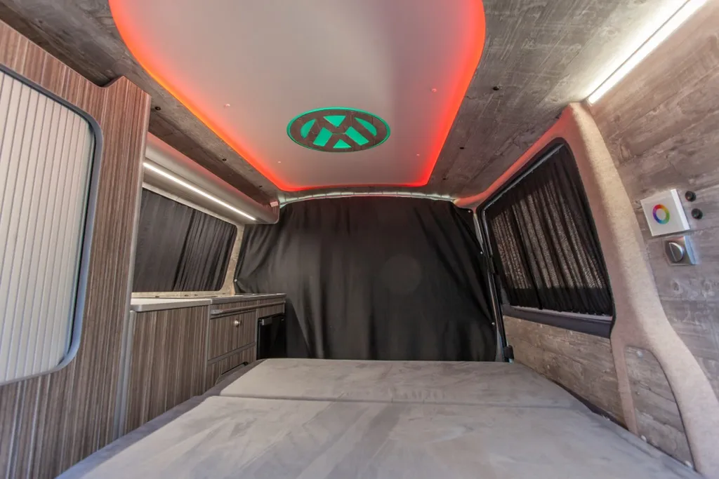 Aménagement intérieur sur-mesure VW Transporter T6 L1H1 avec plafonnier signature logo VW rétroéclairé à Paris et en Île-de-France