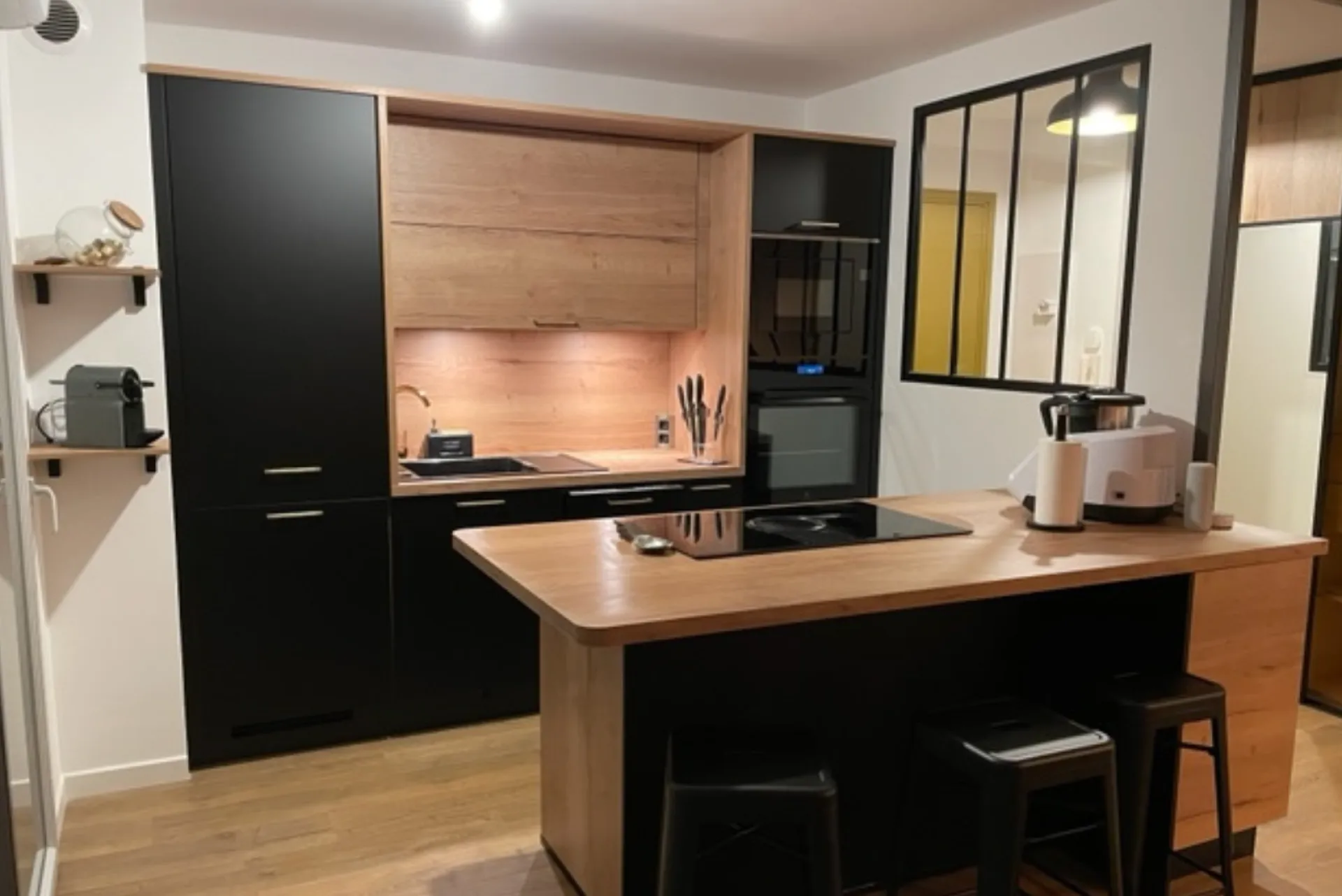 Cuisine noire et bois, poignées dorées dans un appartement T3 au centre-ville de Toulouse