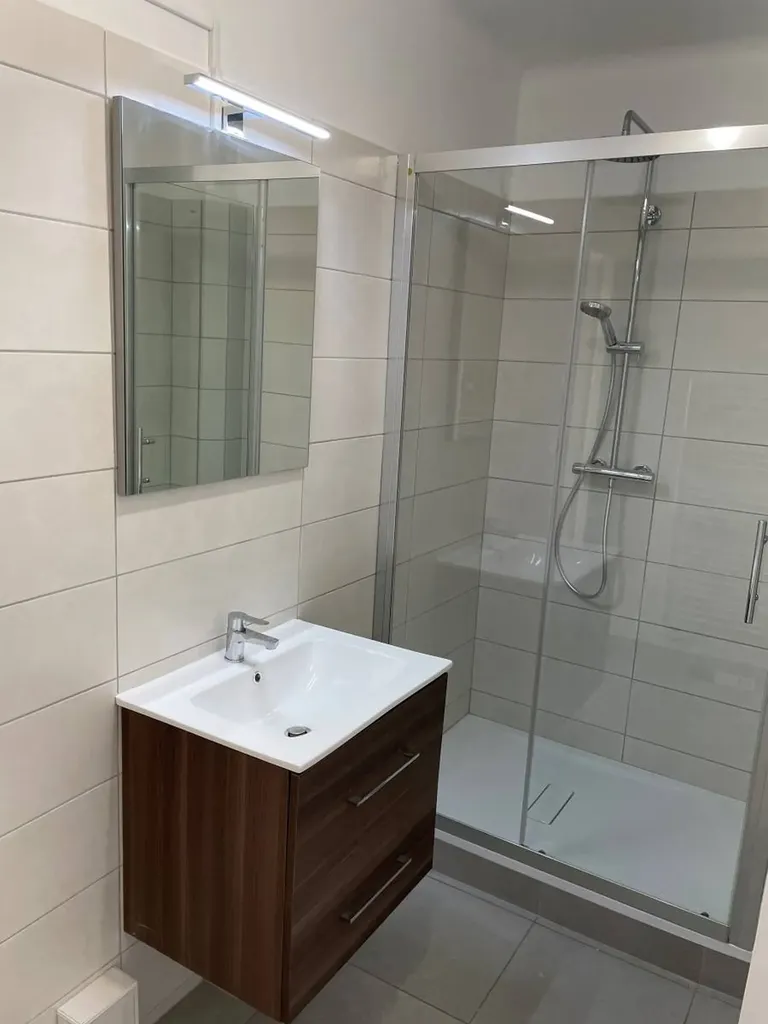 alle de bain rénovée avec douche, meuble vasque, chauffe-eau et radiateur électrique