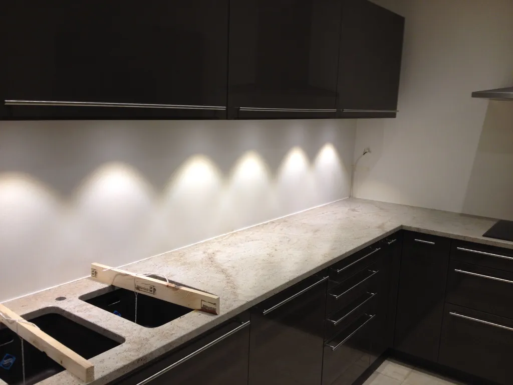 Installation d’un double évier collé sous le plan de travail en granit lors de la rénovation d’une cuisine à Collonges-au-Mont-d’Or (Rhône – 69)