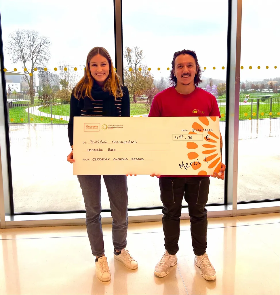 Axel PEREIRA community manager de SUNROC Menuiseries reversant le chèque à l'Oncopole