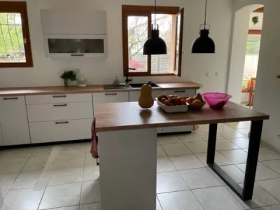 Réaménagement complet d’une cuisine ouverte sur-mesure avec façades grises soie super mat et plans de travail en stratifié coloris chêne à Toulouse.