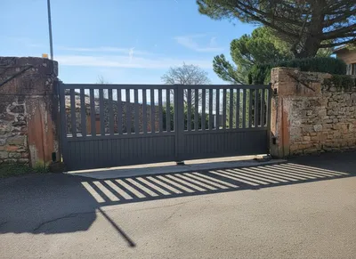Installation d'un portail battant motorisé en aluminium gris anthracite à Meximieux dans l'Ain par 3 Baies