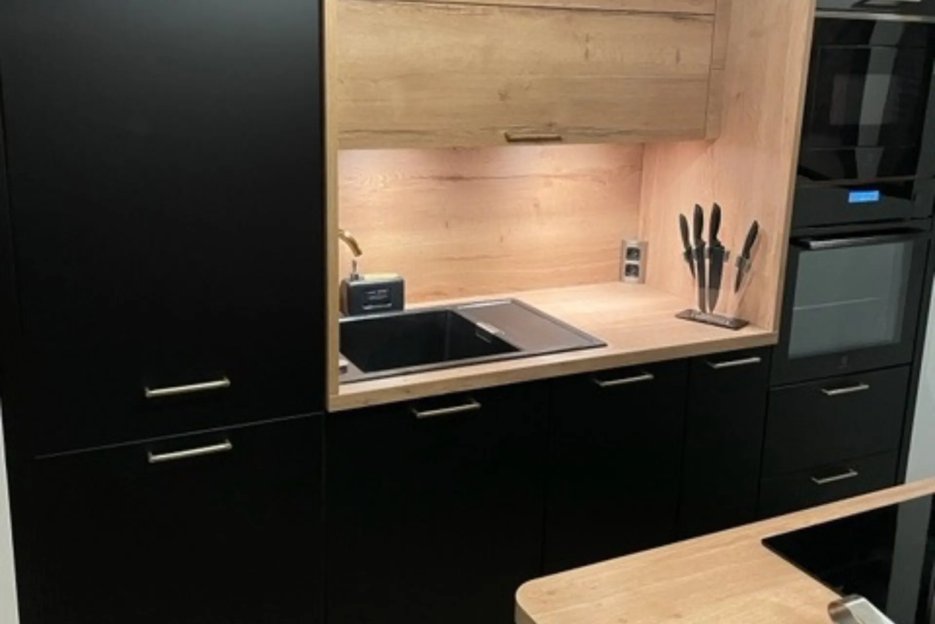 Cuisine noire et bois, poignées dorées dans un appartement T3 au centre-ville de Toulouse