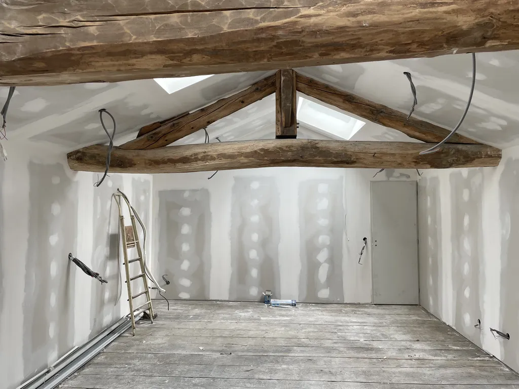 Travaux de pose de plaques de plâtre (placo) lors de l’aménagement des combles à Gleizé près de Belleville-en-Beaujolais (Rhône – 69), pour la création des cloisons et des doublages isolants