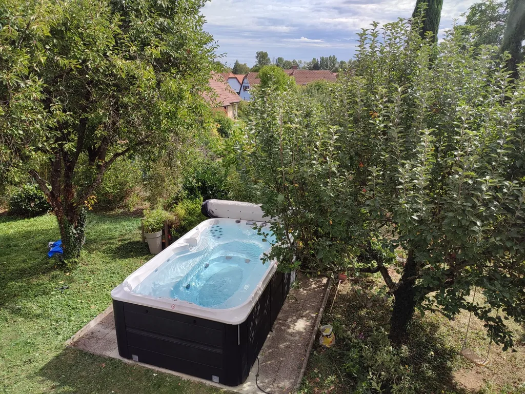 Spa Jacuzzi J13 dans un jardin extérieur autour des oliviers