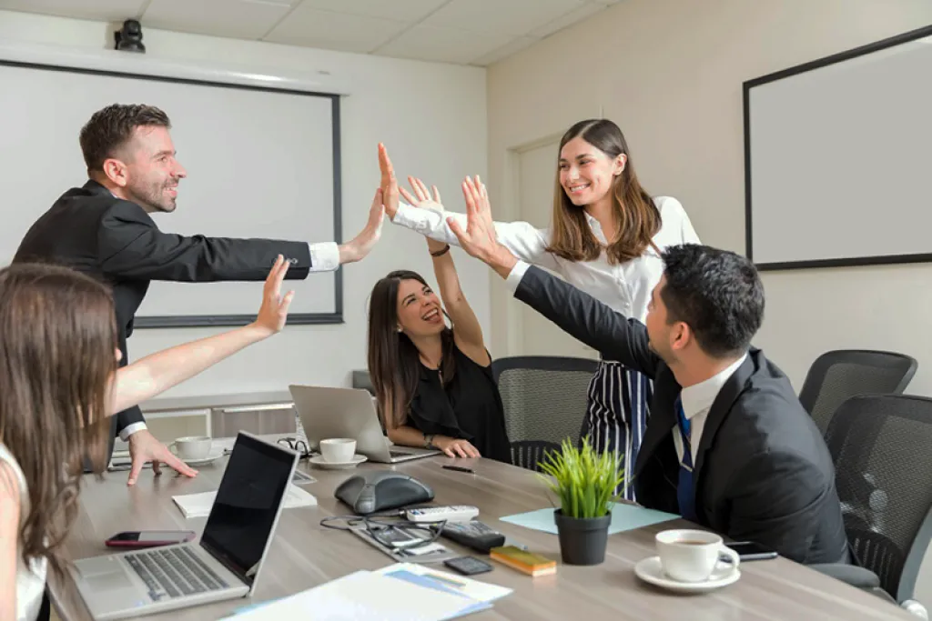 Équipe dirigeante de scale-up Tech célébrant une réussite en réunion – accompagnement Pronexxus pour restaurer la coopération et remettre l’humain au centre de la performance collective à Paris et La Défense