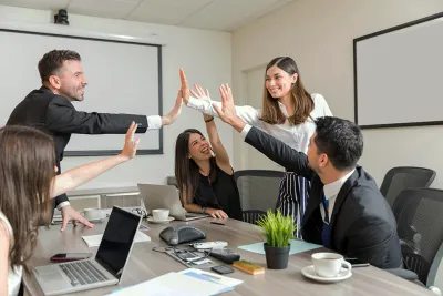 Équipe dirigeante de scale-up Tech célébrant une réussite en réunion – accompagnement Pronexxus pour restaurer la coopération et remettre l’humain au centre de la performance collective à Paris et La Défense