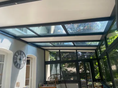 Véranda sur-mesure par 3 Baies avec profilés alu gris anthracite et toiture semi-vitrée à Pelussin près de Saint-Chamond dans la Loire