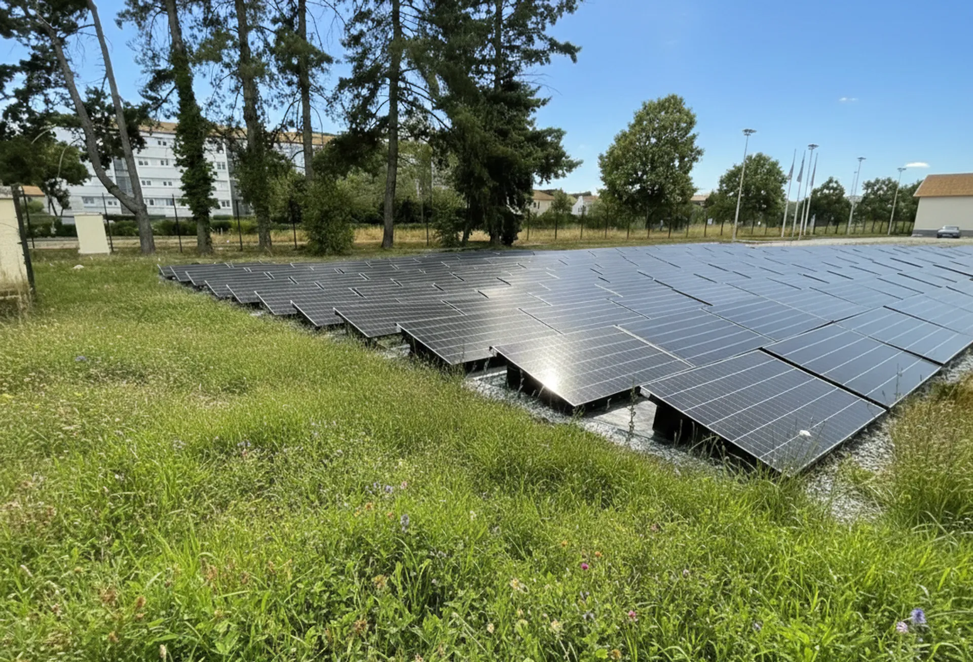 Champ de panneaux solaires montés sur structures au sol métalliques à proximité d’un site technique près d’Angoulême.