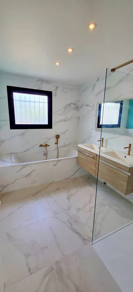 Transformation complète d'une salle de bain dans un style moderne en marbre et or brossé chez un client à Buzet-sur-Tarn