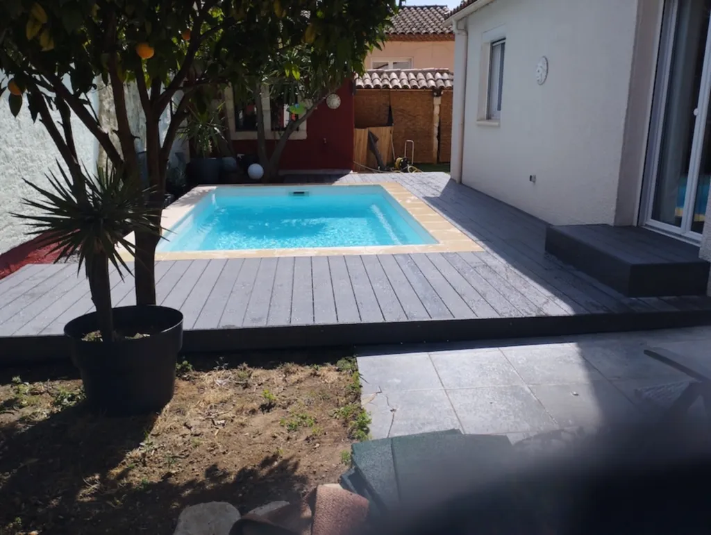 Terrasse en composite de 25 m² autour d’une piscine design moderne, sécurité et entretien simplifié à Mauguio proche de Baillargues