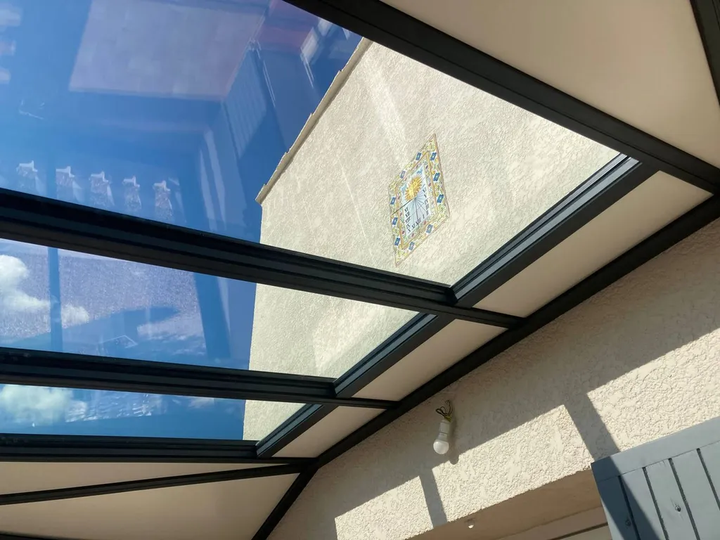 Installation d'une véranda intégrée sur une terrasse dans une maison de village sur la commune de Milhaud