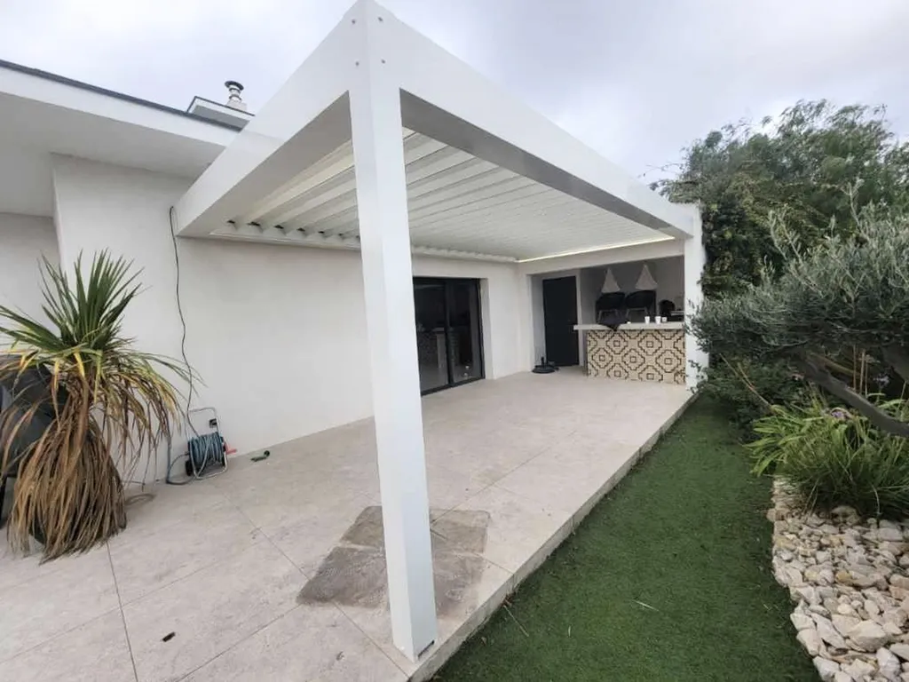 Pergola bioclimatique aluminium RAL 9010 fabrication française avec deux poteaux pour terrasse moderne élégante sur mesure durable