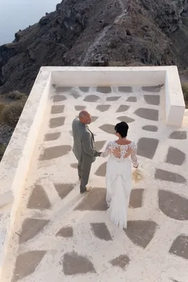 Une cérémonie de mariage civile romantique organisée sur la terrasse d'un hôtel de luxe avec vue sur la Caldera à Santorin