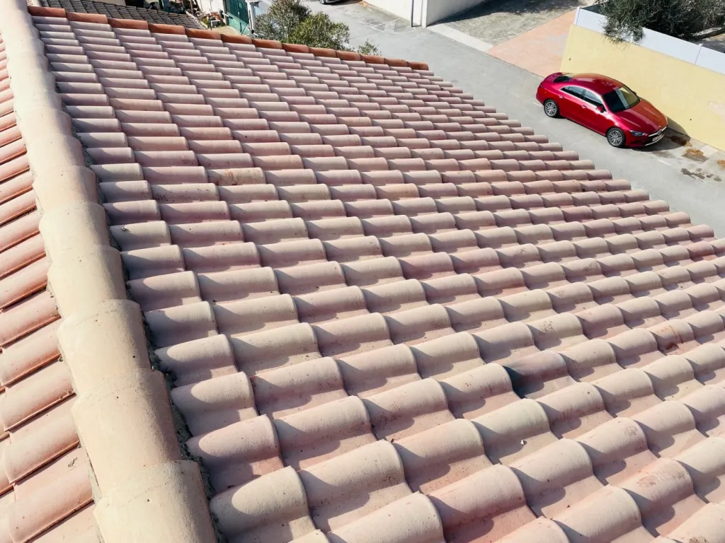 Nettoyage et traitement des tuiles mécaniques Romane d’une toiture de maison près d’Aix en Provence.