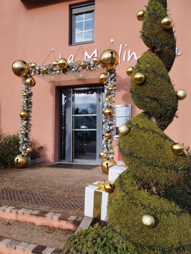 Décoration de Noël du restaurant « le Moulin du Gastronome » avec guirlandes artificielles garnies de boules or et blanches de différentes tailles et lumières scintillantes à Charnay-lès-Mâcon