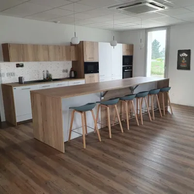 Cuisine ouverte sur l’espace de restauration, favorisant convivialité et bien-être dans une entreprise de Martillac, par l’Atelier D. architecte d’intérieur à Bordeaux.