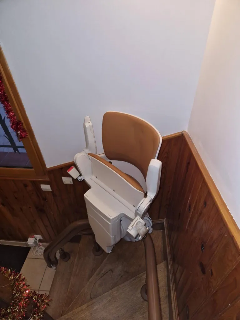 Fauteuil monte escalier OTOLIFT Modul'Air Smart avec siège et accourdoirs repliés sur son point de charge dans cet escalier courbe près d'Aix en Provence 