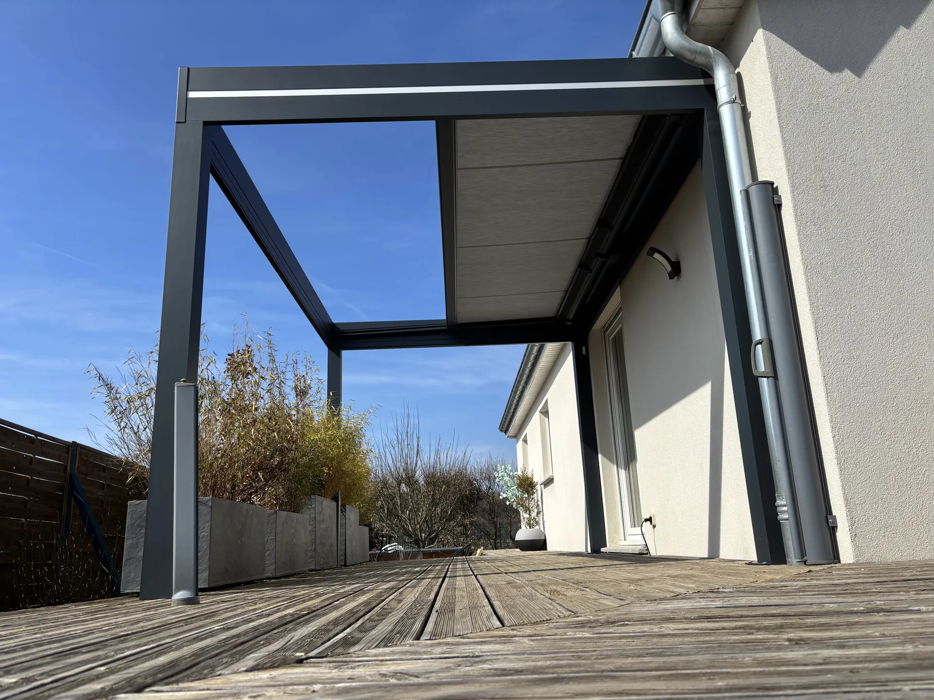 Réalisation d’une pergola store  dans le Territoire de Belfort à  Sermamagny 90300 coloris 7016, toiles Dickson imperméable couleur gris souris