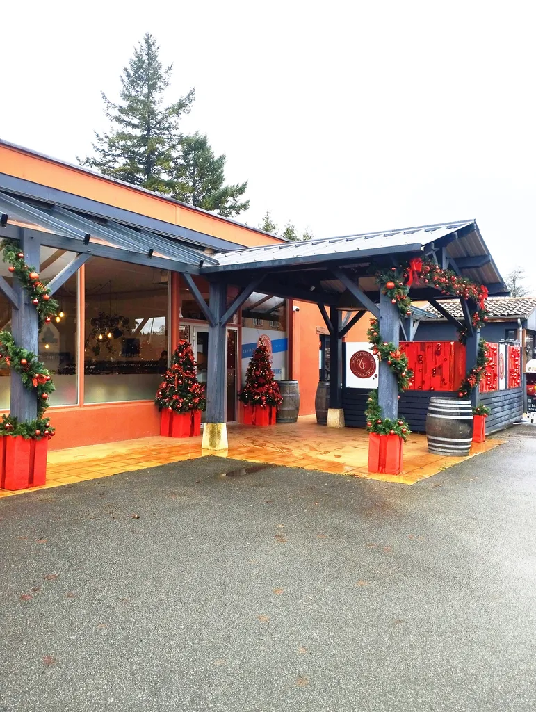 Décoration de Noël de la Cave des Tournons avec sapins synthétiques, guirlandes artificielles et tableaux de Noël garnis de boules rouges gourmandes à Charnay-lès-Mâcon