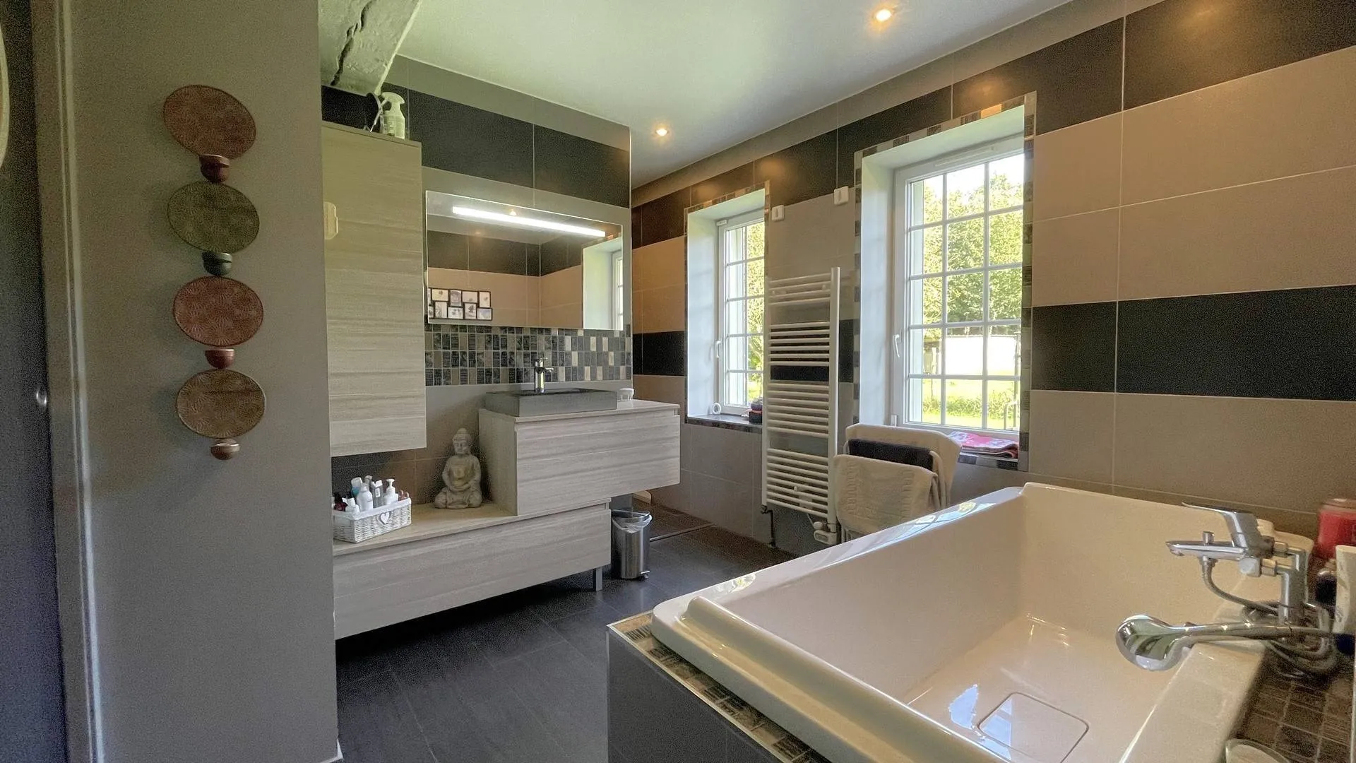 Longère avec salle de bain et douche à vendre : Le rez-de-chaussée comprend une salle de bain moderne équipée d’une douche et d’une baignoire, ainsi qu’un WC indépendant.