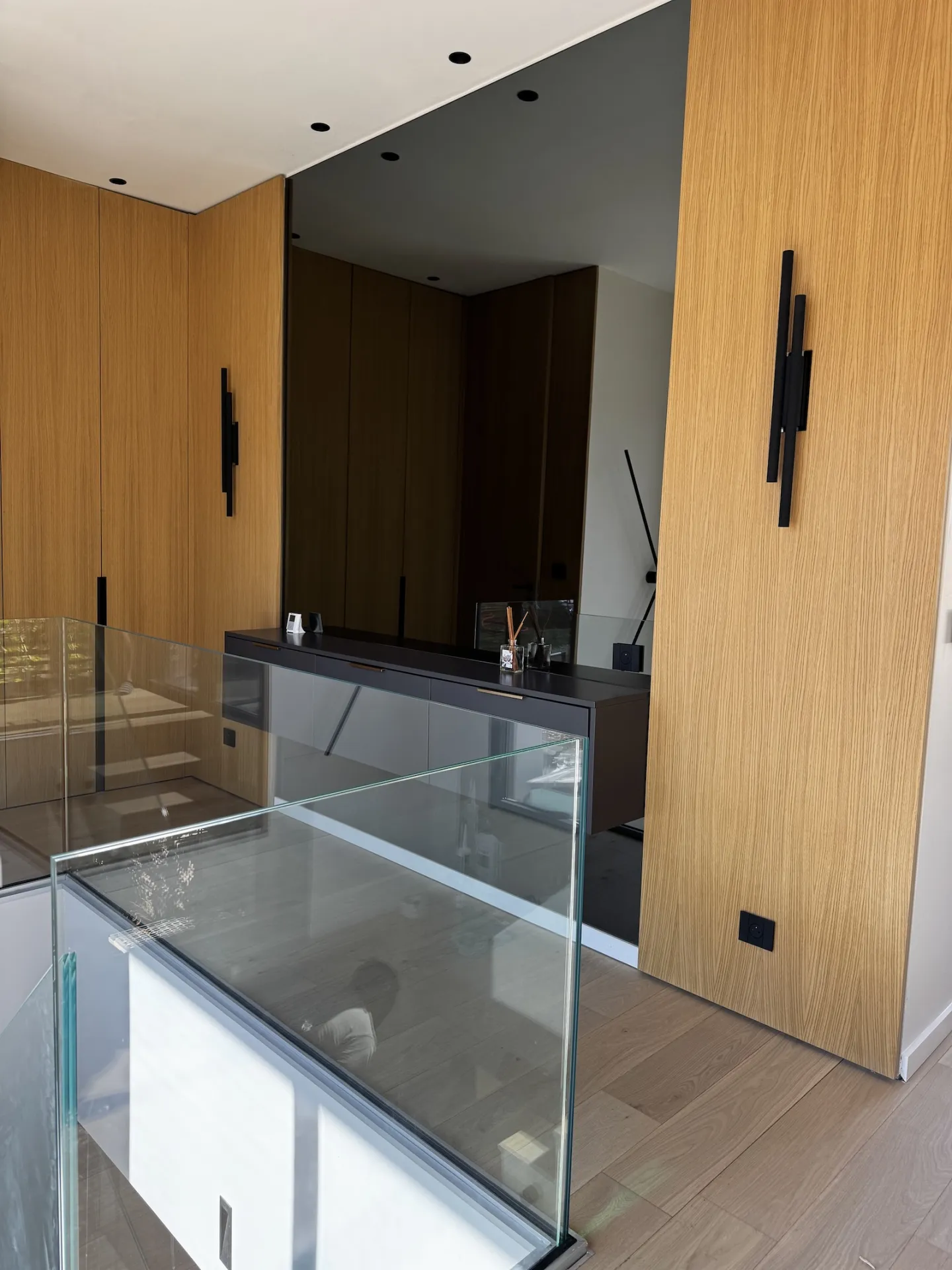 Vue intérieure sur la trémie d’escalier protégée par un garde-corps en verre, intégré discrètement au sol.