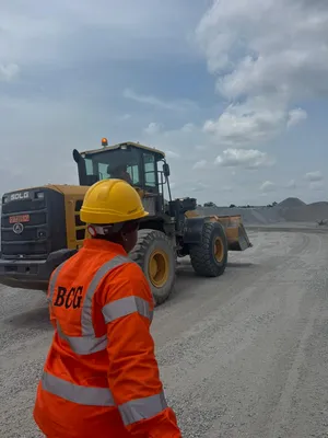 Opérateur et chargeuse sur le site BCG au Bénin, dans la zone de manutention des granulats destinés aux chantiers du BTP.