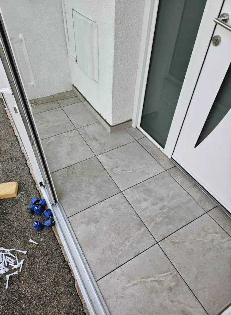 Réalisation d'une terrasse chez un particulier à Lagnieu dans l'Ain avec démolition de l'ancienne dalle, ragréage et pose de carrelage