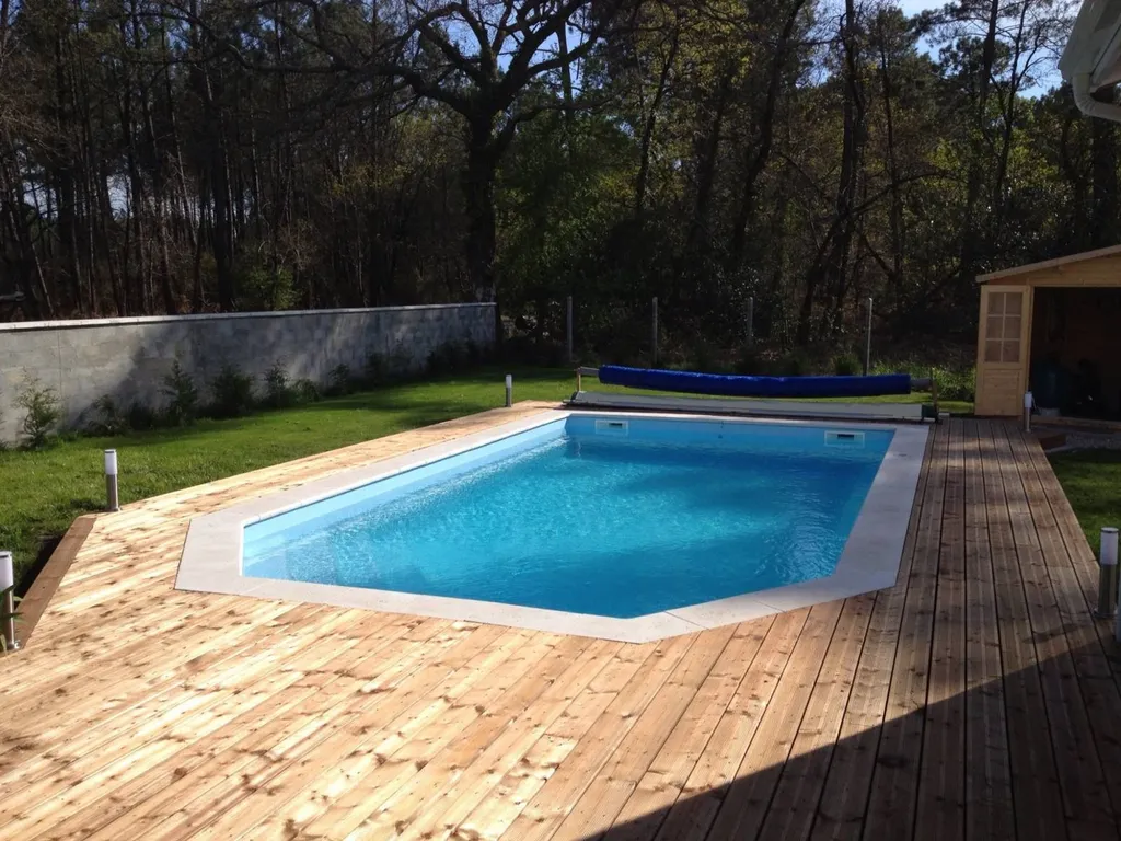 Piscine dans jardin avec terrasse planchée