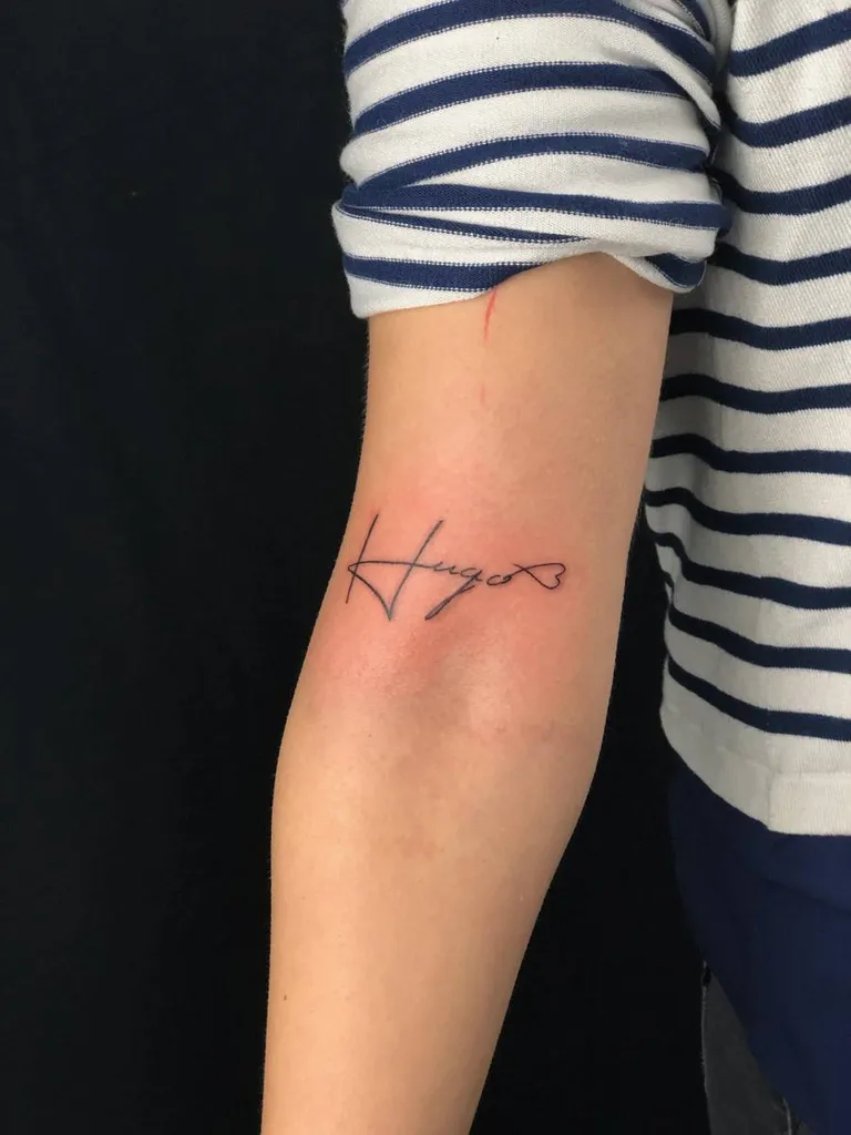 Tatouage d'un prénom avec une écriture fine à Craponne