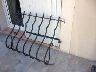 MODIFICATION GRILLES DE SECURITE EN FER FORGE AVEC BARREAUDAGE GALBE ET VOLUTES LATERALES A MARTIGUES