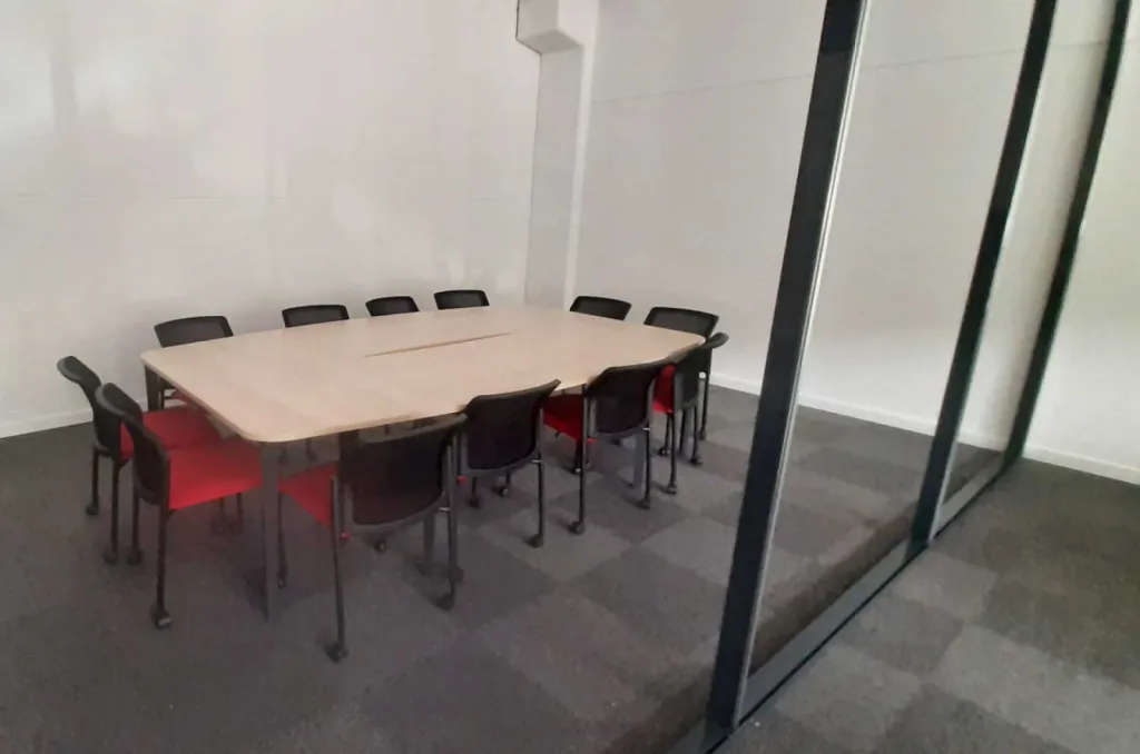 Aménagement de 270 m² de bureaux pour 32 postes à Brignoles avec mobilier ergonomique Made in France, gestion des câbles, acoustique optimisée et identité rouge-noir-bois