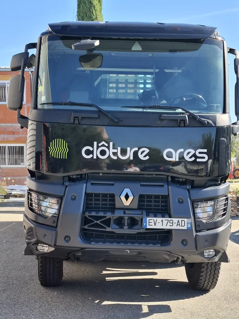 Flocage et lettrage adhésif sur la calandre avant du camion poids lourd Clôture Ares par Fuzz Communication.