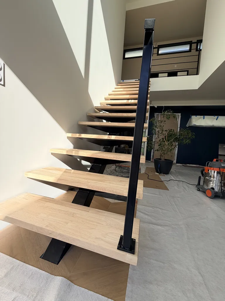 Escalier métallique sur mesure avec limon central et marches en hévéa verni à Toulouse par Sud Ouest Metal