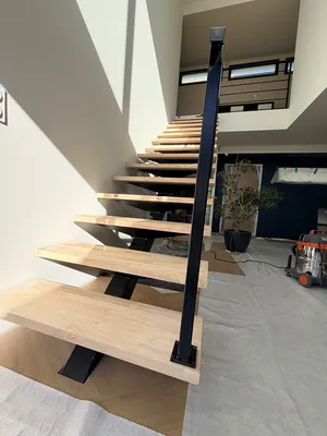 Escalier métallique sur mesure avec limon central et marches en hévéa verni à Toulouse par Sud Ouest Metal