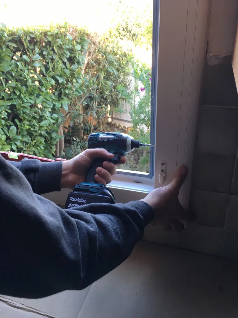 PENDANT La pose des vis sur le dormant de la fenêtre