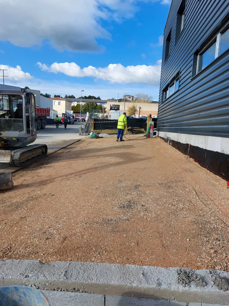 Réalisation du parking d'un entrepôt en enrobé de bitume noir à Septême les Vallons dans les Bouches du Rhône