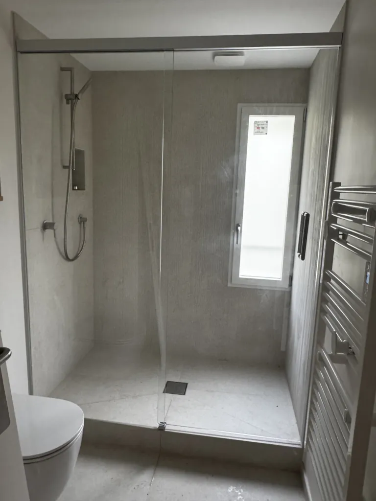 Installation d’un ensemble de douche avec partie fixe et porte coulissante à Annecy