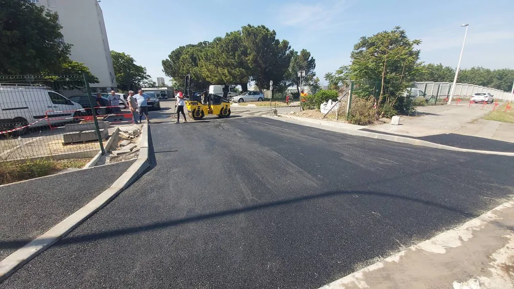 Application d'enrobé de bitume noir dans une entrée de copropriété à Marseille dans les Bouches du Rhône