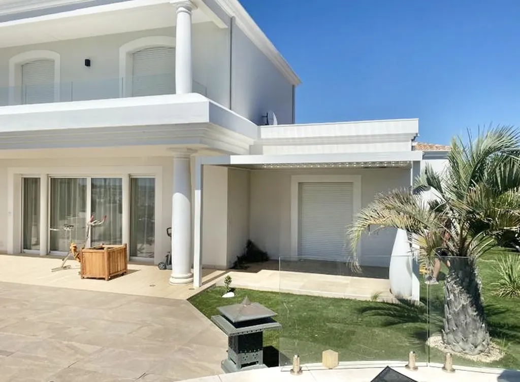 Installation de Pergola bioclimatique aluminium blanc avec deux poteaux fabrication française design moderne pour extérieur confortable et durable