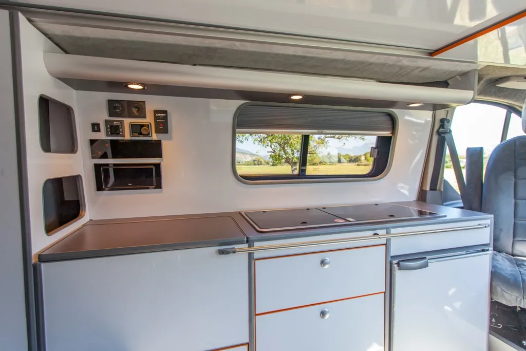 Aménagement intérieur sur-mesure Ford Transit Custom L2H1 Sport avec mobilier blanc laqué et chants orange à Annecy en Haute-Savoie