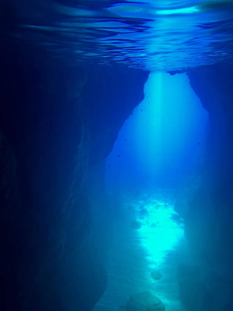 Entrée de la grotte marine de l'Oule, uniquement accessible à la nage, avec des reflets turquoise dans l'eau
