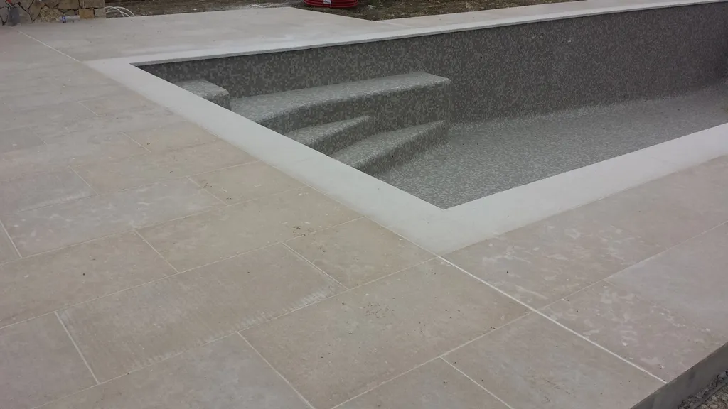 dallage pierre naturelle beige autour d'une piscine