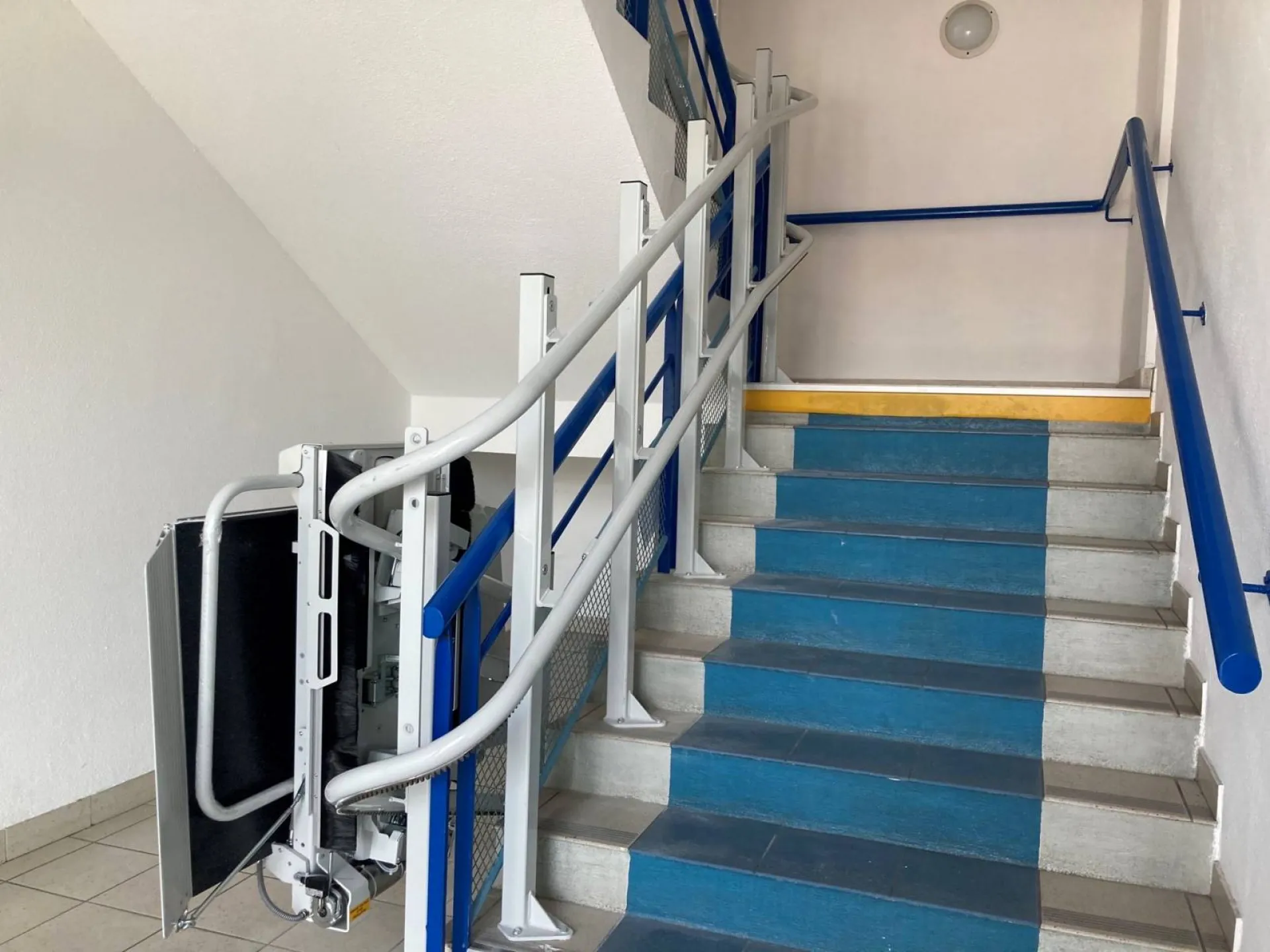 Plateforme oblique LEHNER STRATOS installée dans un escalier courbe en intérieur dans cet immeuble de bureaux à Toulon près de Marseille